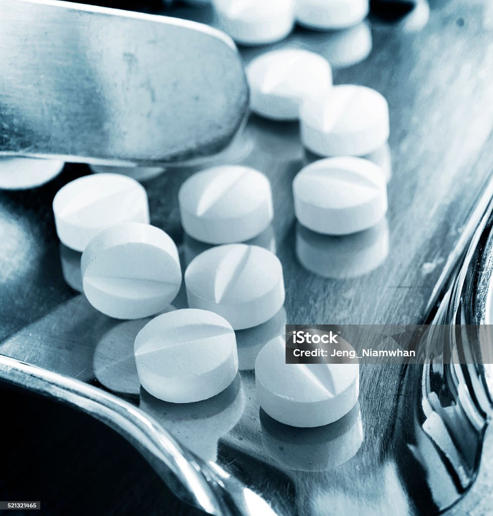 Medical pills Close-up of two white medical pills on stainless steel tray. Capsule - Medicine Stock Photo