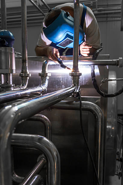 istock Man welding stainless steel pipes 521342191