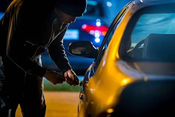 Car thief stealing a car.