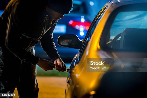 Foto de Ladrão De Carro Usando Uma Chave De Fenda Para Frear Em Um Carro e mais fotos de stock de Roubando - Crime
