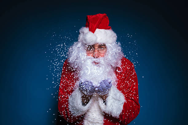 istock Santa Claus with glasses blowing snow 521343081