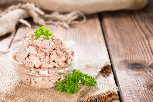 Portion of (canned) Tuna with fresh herbs as detailed close-up shot