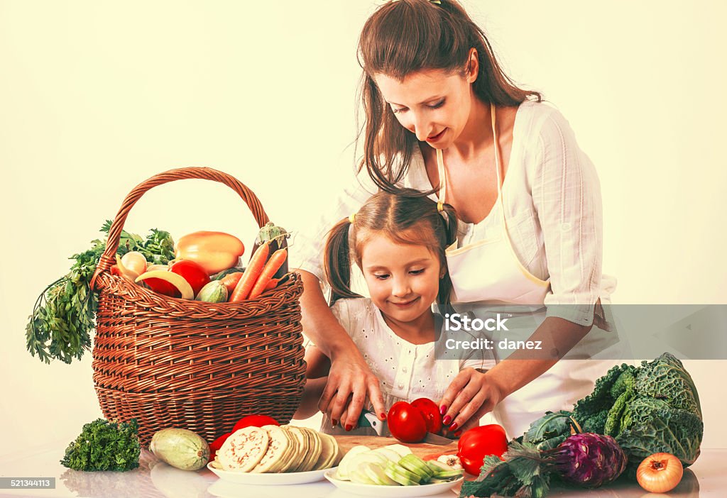 Happy modern lunch making and learning Mom and daughter making nice, healthy and very organic lunch from bunch of vegetables, all happy and  shining from innerself. Really amazing and cool staff. Adult Stock Photo