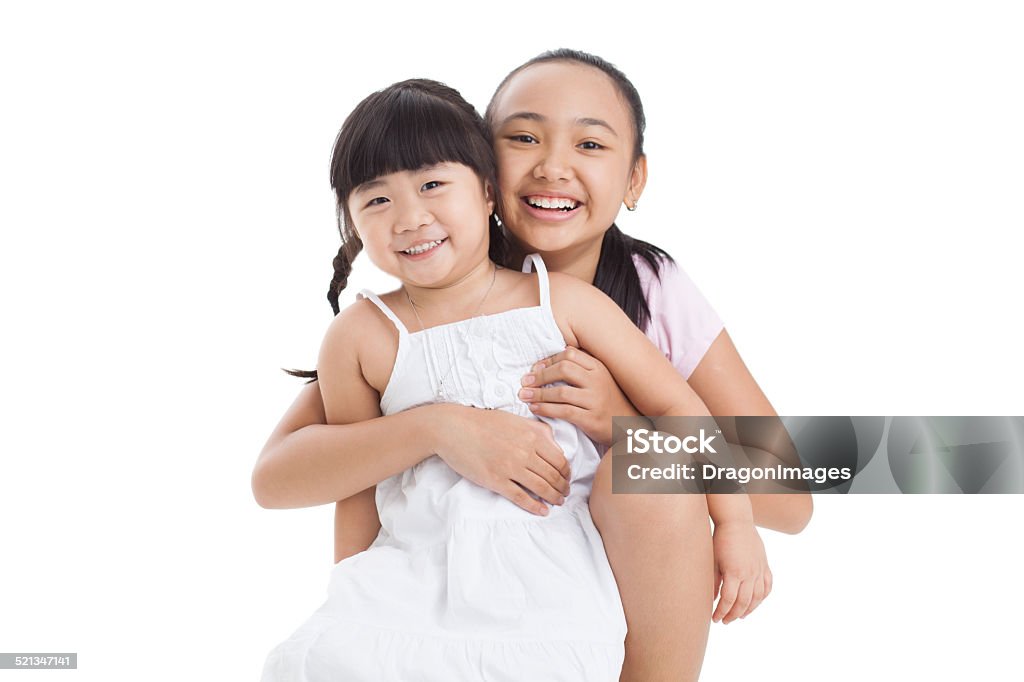 My little sister and me Isolated portrait of two cute sisters cuddling in front of the cam Affectionate Stock Photo