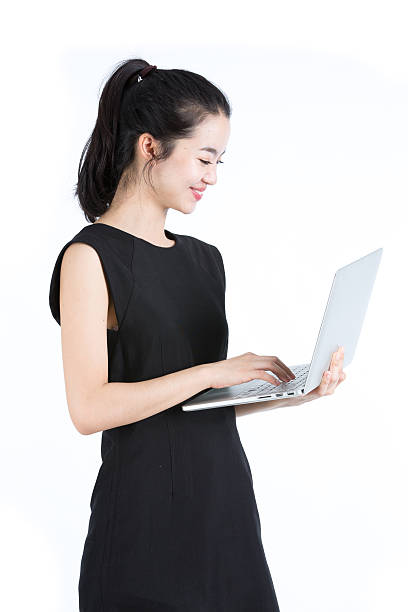 Asian business woman using a laptop, standing stock photo