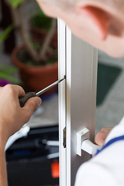 istock Handyman repairing window with screwdriver 521348523
