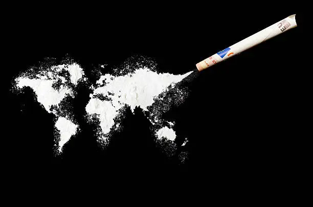 A top shot of a powder drug like cocaine in the shape of the world (Continent) with a rolled money bill.(series).Inspired by the world we do live in.