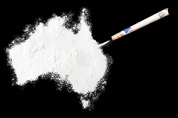 Powder drug like cocaine in the shape of Australia A top shot of a powder drug like cocaine in the shape of Australia (Continent) with a rolled money bill.(series).Inspired by the world we do live in. cocaine stock pictures, royalty-free photos & images