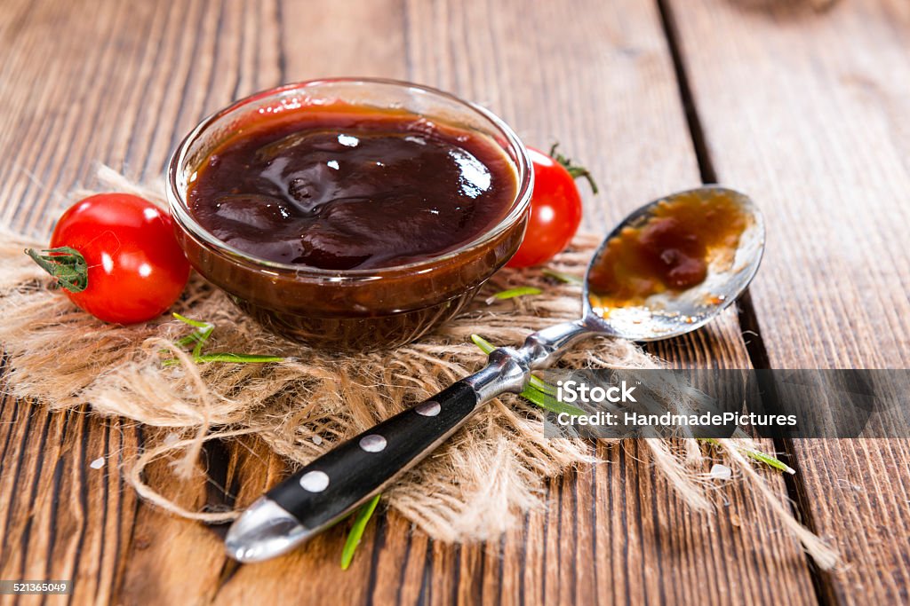 Barbeque Sauce Barbeque Sauce with Tomatoes, Smoked Salt and fresh Herbs (on rustic wooden background) Barbeque Sauce Stock Photo