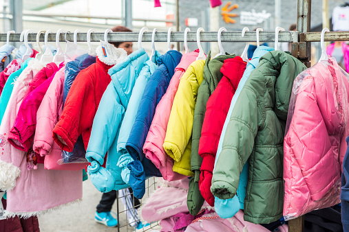 Badalona, Spain - November 1, 2014: Stall clothes in the market Turo Caritg in Badalona, a town next to Barcelona. The vendors serve customers while they choose and seek something you like