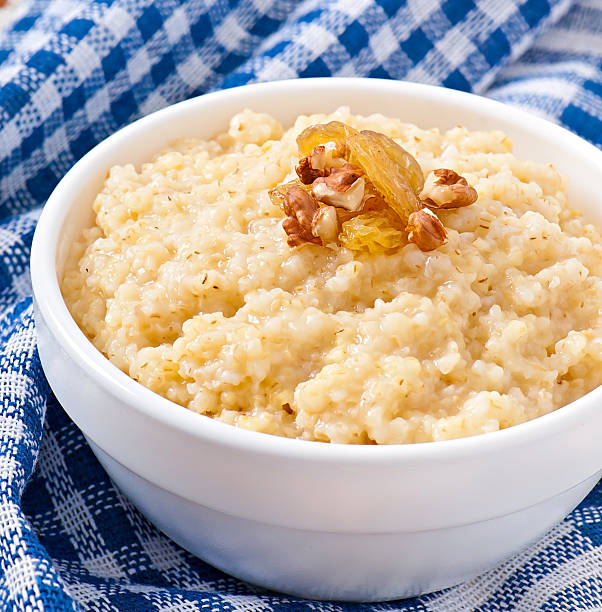 haferbrei in eine schüssel mit nüssen und rosinen - oatmeal porridge oat raisin stock-fotos und bilder