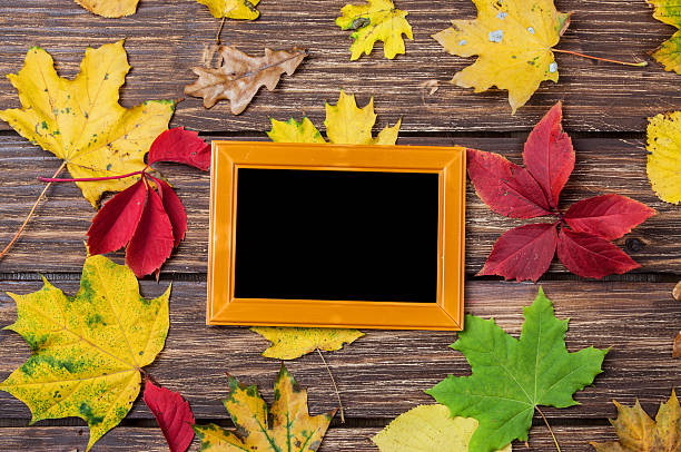 istock Autumn leafs and frame for photo on wooden table. 521371771