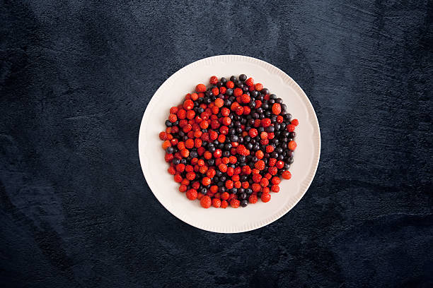 Forest berry strawberries and blueberries on a white plate