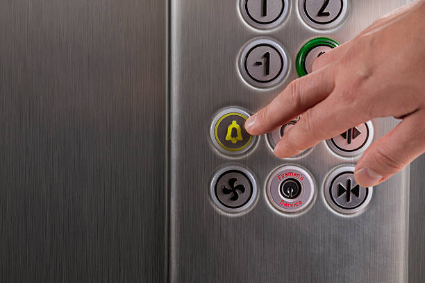 рука нажав на кнопку «будильник» в лифте - elevator push button control panel moving up стоковые фото и изображения