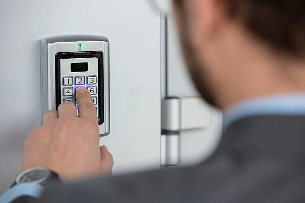 Close up of businessman hand entering security system code Human hand pressing the security code combination to unlock the door    burglar alarm stock pictures, royalty-free photos & images