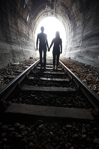 istock Couple walking together through a railway tunnel 521374744