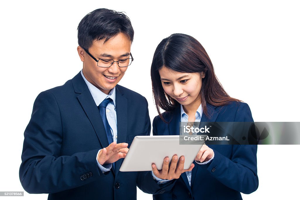 Working together to achieve success Portrait of an asian businessman and businesswoman using digital tablet, isolated on white. They are looking at digital tablet. 20-29 Years Stock Photo