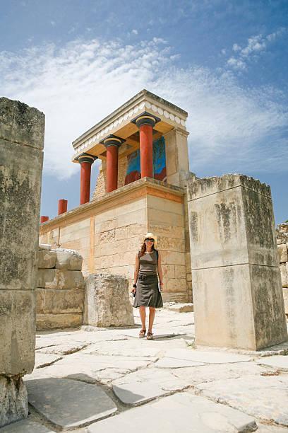 woman traveler tourist walking in landmark monument minoan Knossos palace ruins, from 2000 year Before Christ, one of the most important greek monuments in Crete Greece Europe