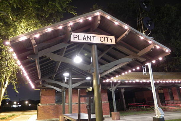 Plant City, Florida Old Train Station at night. Illuminated by a chain of lights that go around the eaves of the roof, the original and antique Plant City, Florida train station glows like a silent beacon in the night and hearkens back to the day when it was a major train hub in the state of Florida. Although it is no longer in use it is a historical reminder of Plant City's involvement in the importance of railroads in America. plant city photos stock pictures, royalty-free photos & images