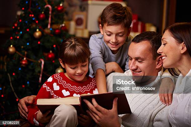 Discutiendo De Libro Foto de stock y más banco de imágenes de Familia - Familia, Libro, Navidad