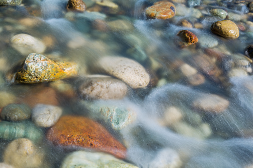Pebble stones in the river water close up view,