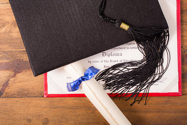 istock Graduation!  Cap, motarboard and tassel with dilplomas on table. Education. 521384154