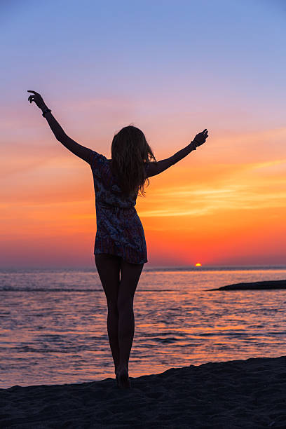 istock Beautiful young woman on the beach sunset 521384224