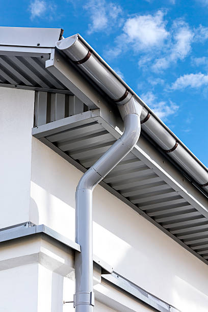 new gray metal rain gutter on house rooftop newly installed gray rain gutter on house rooftop downspout stock pictures, royalty-free photos & images
