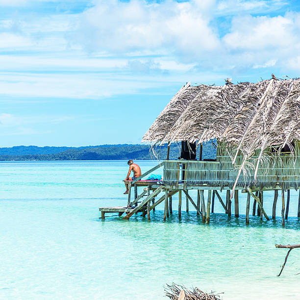 istock Man Sitting in a Beach Hut by the Sea 521384820