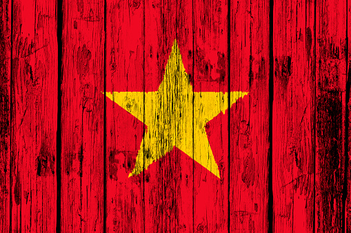 Vietnamese national flag painted on an old wooden door with flakey paint