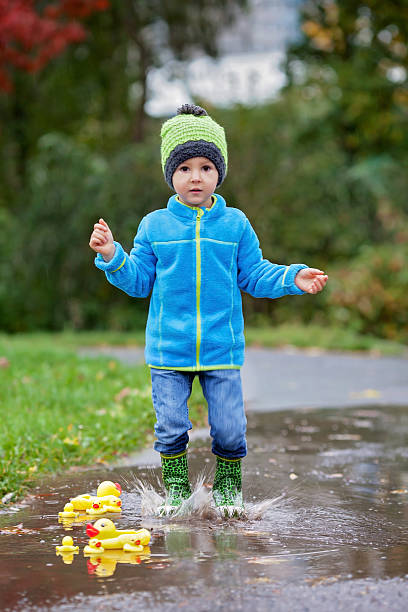 istock Little boy, jumping in muddy puddles 521385189