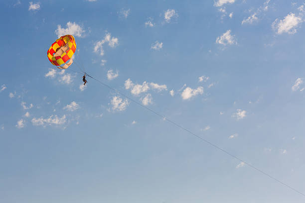 istock Man parasailing over the sea 521385660