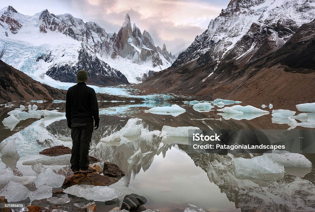 Man standing watching the sunset at Laguna Torre. Patagonia Argentina SELF-PORTRAIT. Person standing quietly on a rock watching the sunset at the lake and mountains. Patagonia Argentina Stock Photo