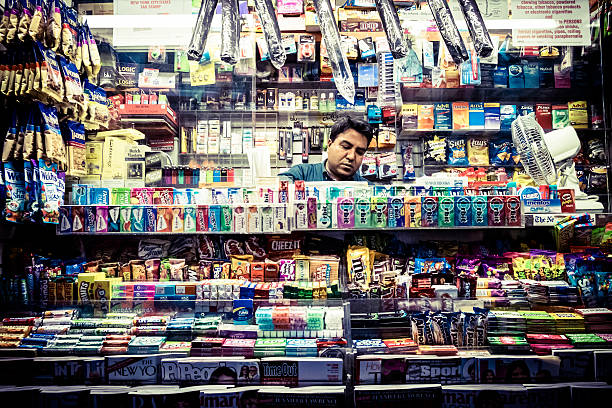 Magazines, candy and snack street shop New York, New York, USA- October 16, 2014: Asian man selling at a Magazines, candy and snack street shop in New York City convenience store photos stock pictures, royalty-free photos & images