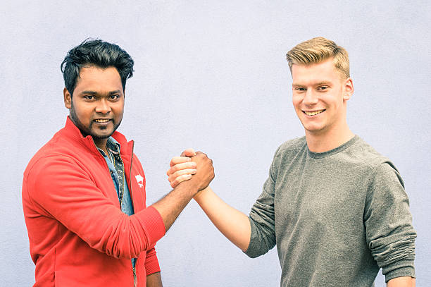 istock Indian and caucasian men shaking hands in a modern handshake 521386324
