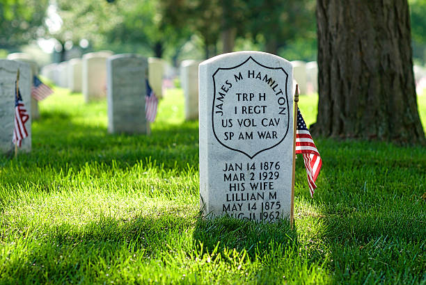 Tombstone, U.S. Flag, Spanish-American War, Arlington National Cemetery Arlington, Virginia, USA - May 24, 2015: Tombstone honoring a Spanish-American War veteran and his wife at Arlington National Cemetery on Memorial Day. arlington cemetery in spring stock pictures, royalty-free photos & images