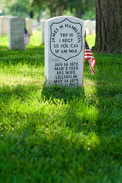 Tombstone, U.S. Flag, Spanish-American War, Arlington National Cemetery Arlington, Virginia, USA - May 24, 2015: Close-up of a small U.S. flag and tombstone honoring a Spanish-American War veteran and his wife at Arlington National Cemetery. arlington cemetery in spring stock pictures, royalty-free photos & images
