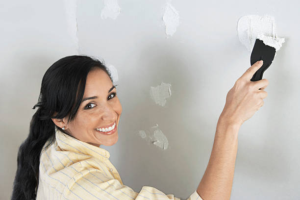 istock Woman Spackling Wall 521386503