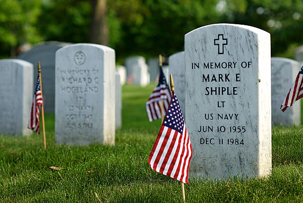 Tombstone, U.S. Flag, Arlington National Cemetery, Close-up Arlington, Virginia, USA - May 24, 2015: Small U.S. flags are placed in front of every tombstone at Arlington National Cemetery each Memorial Day, including this one honoring LT Mark E. Shiple, U.S. Navy. arlington cemetery in spring stock pictures, royalty-free photos & images
