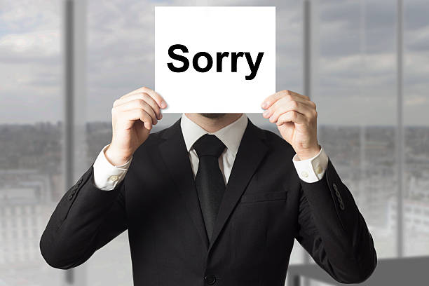 istock businessman hiding face behind sign sorry 521387945