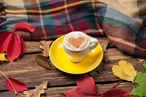 istock Autumn leafs, scarf and coffee cup on wooden table. 521398989