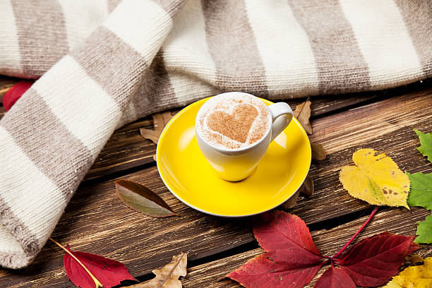 istock Autumn leafs, scarf and coffee cup on wooden table. 521398991