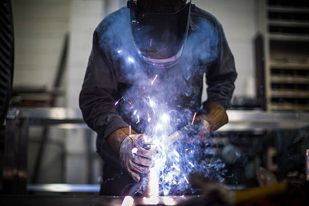 istock Man welds aluminum with an arc welder 521401091