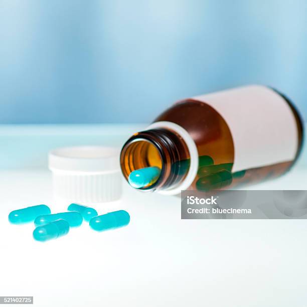 Vertido Cápsulas De Botella Foto de stock y más banco de imágenes de Analgésico - Analgésico, Asistencia sanitaria y medicina, Azul