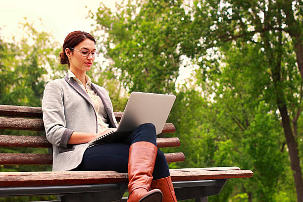 istock Woman with laptop in park 521405077