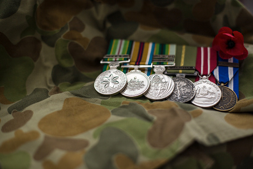 Australian Defence Force service medals resting on an Auscam uniform with red poppy.