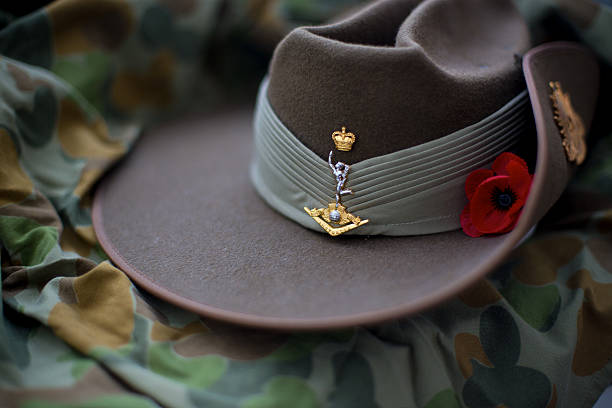 Slouch hat with red poppy Australian Army slouch hat with red poppy resting on an auscam background. poppy plant photos stock pictures, royalty-free photos & images