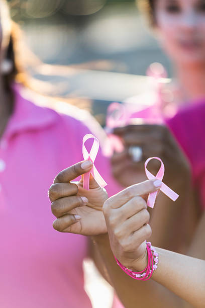 istock Multiracial hands holding breast cancer awareness ribbon 521418524