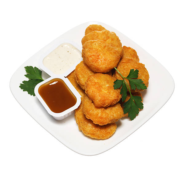istock Chicken nuggets in plate with two dressings isolated 521418773