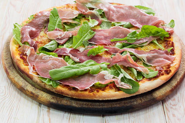istock Pizza with dry cured ham on wood table 521419217